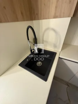 Close-up shot of a kitchen sink and faucet on the countertop. - image 8