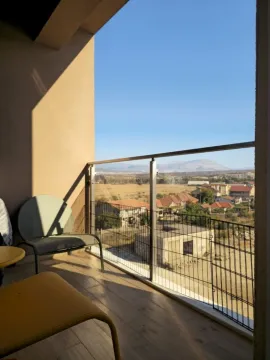 Manji namješteni balkon sa pogledom na naselje i planine. - image 12