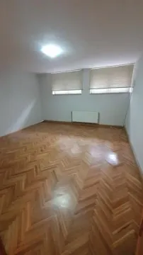 Prazna soba sa drvenim parketom i dva prozora. - image 3