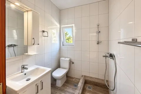 Svijetlo opremljeno kupatilo sa tuš kabinom, umivaonikom i wc šoljom. - image 6