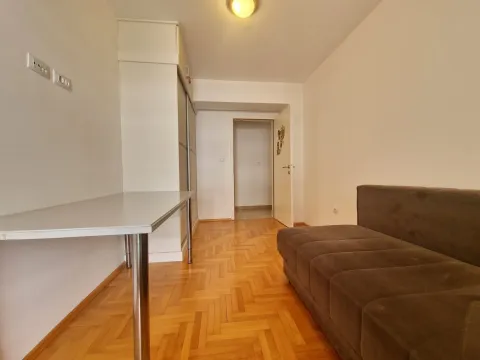 Smaller living room with a brown sofa, a table, and a white wardrobe. - image 19