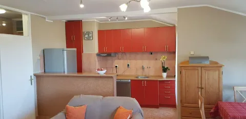 Kuhinja sa crvenim elementima, šankom i trpezarijskim stolom. - image 12