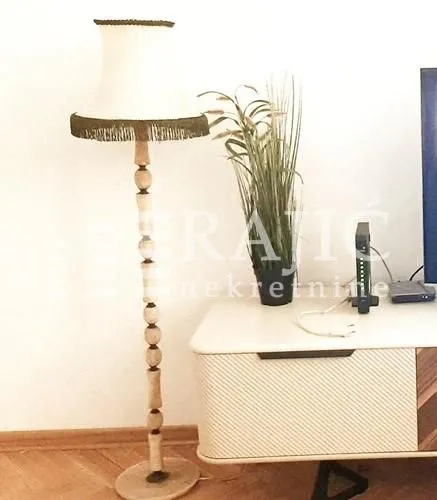 Dnevna soba sa podnom lampom i komodom.