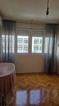 Prazna soba sa prozorom, drvenim parketom i tamnim zavjesama. - image 6