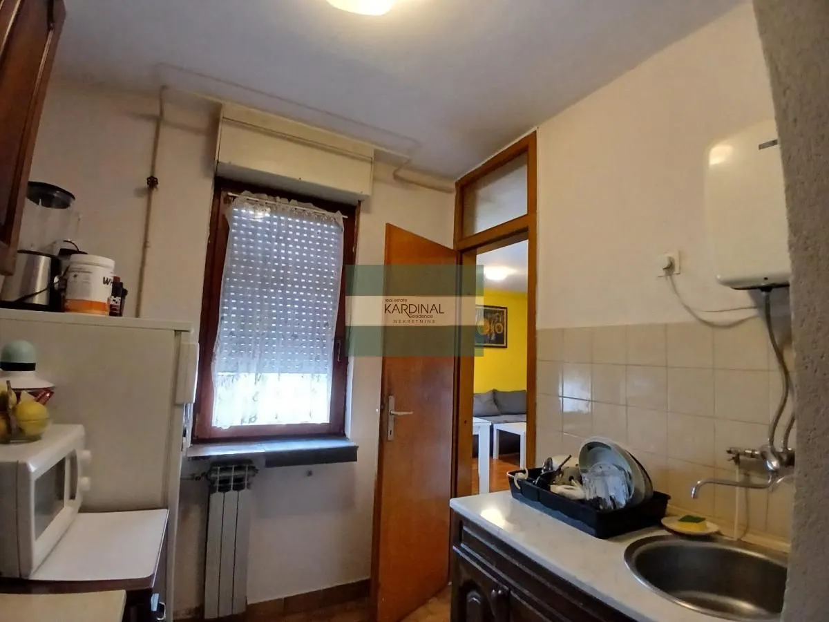 Manja kuhinja sa sudoperom i radnom površinom.