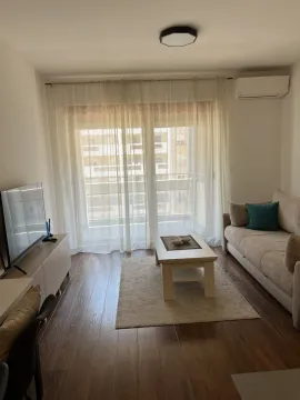 Svijetla dnevna soba sa udobnim kaučem, televizorom i izlazom na balkon. - image 12