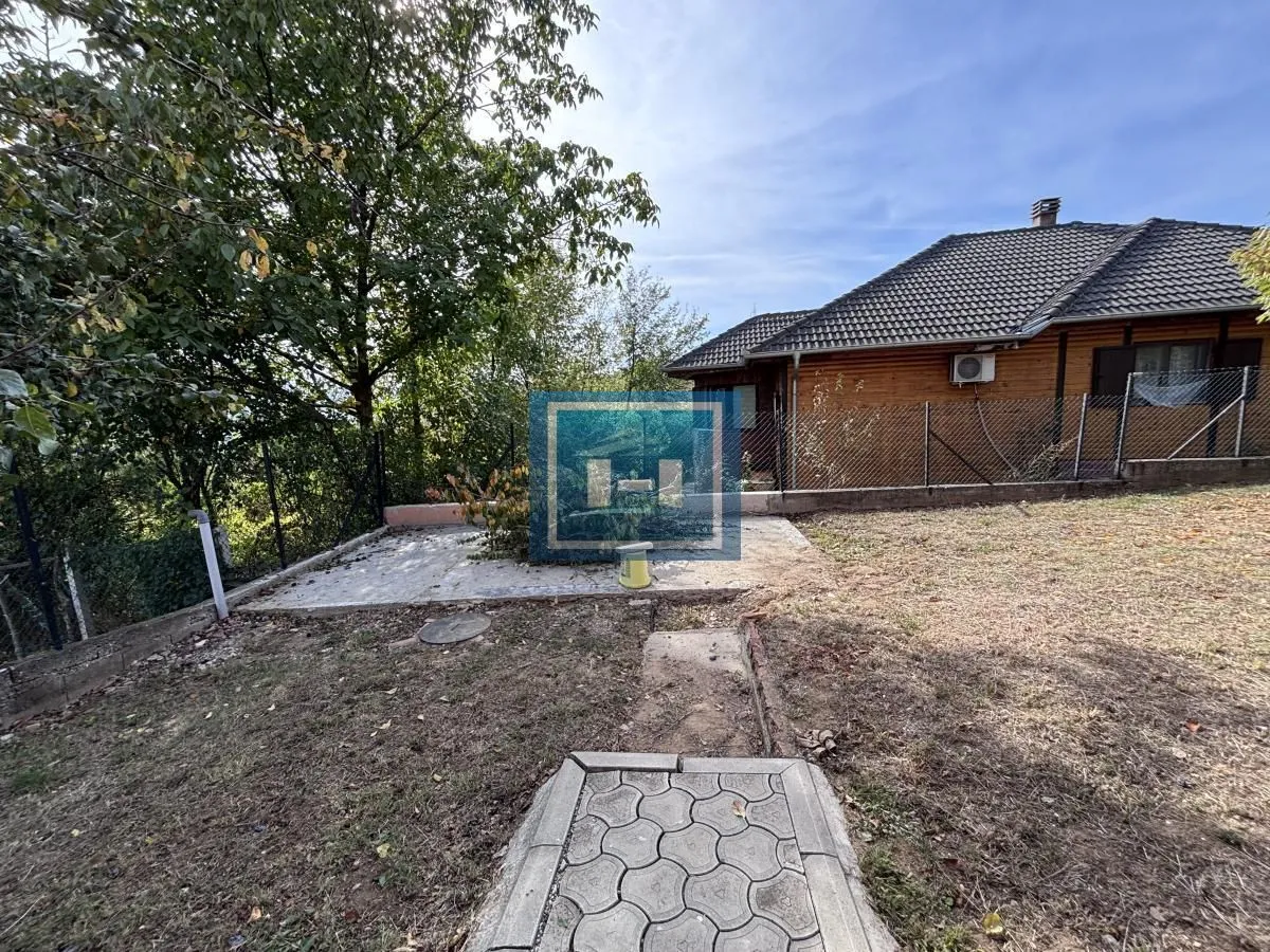 Pogled na dvorište i spoljašnjost kuće sa drvenom fasadom.