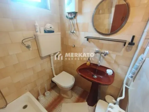 Manje kupatilo obloženo keramičkim pločicama sa WC šoljom, umivaonikom i ogledalom. - image 18