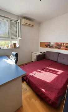 Manja spavaća soba sa krevetom, radnim stolom i klima uređajem. - image 4