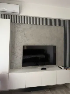 Living room with TV cabinet and decorative wall. - image 4