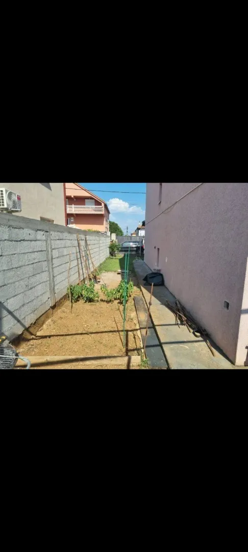 Narrow side yard next to the house with a small garden area.