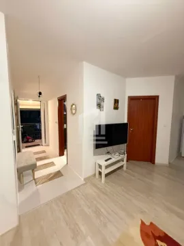 Living room with a TV and a view of the hallway and entrance door. - image 4