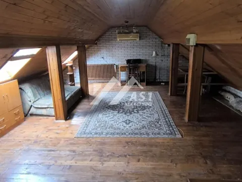 Attic space with wooden paneling on the ceiling and walls, furnished with a sofa and carpet. - image 7