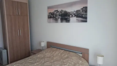Svijetla spavaća soba sa bračnim krevetom, ormarom i umjetničkom slikom na zidu. - image 4