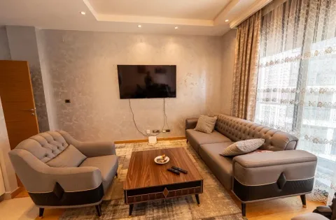 Comfortable living room with sofa, armchair, coffee table and wall-mounted TV. - image 4