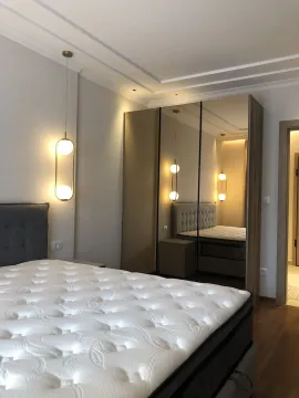 Bright bedroom featuring a modern bed and a built-in wardrobe with mirrored doors. - image 21