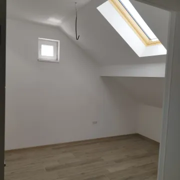 Prazna potkrovna prostorija sa krovnim prozorom i drvenim podom. - image 15