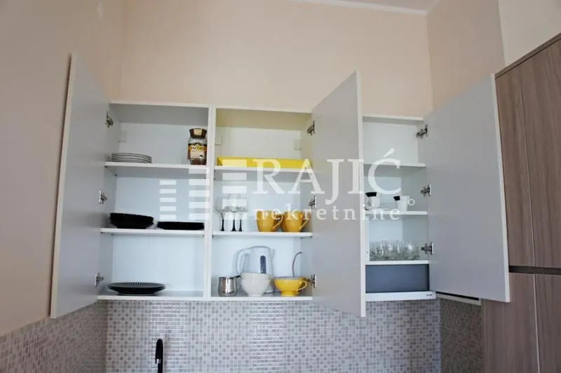 Open kitchen cabinets with dishware.