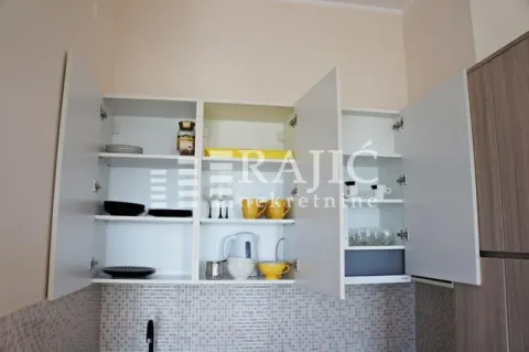 Open kitchen cabinets with dishware. - image 12