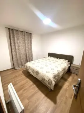 Furnished bedroom with a double bed, bedside table, and a window with curtains. - image 3