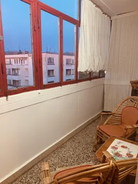 Enclosed balcony with wicker furniture. - image 10