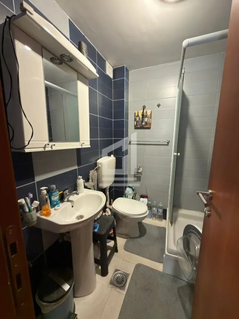 Manje kupatilo sa umivaonikom, WC šoljom i tuš kabinom.
