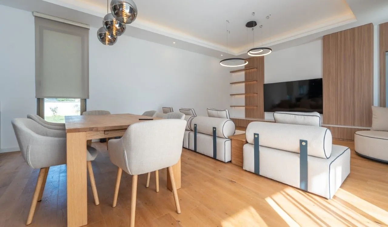 Modern living room with a dining area and TV unit.