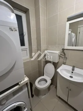 Manje kupatilo sa WC šoljom, umivaonikom, ogledalom i mašinama za pranje veša. - image 2