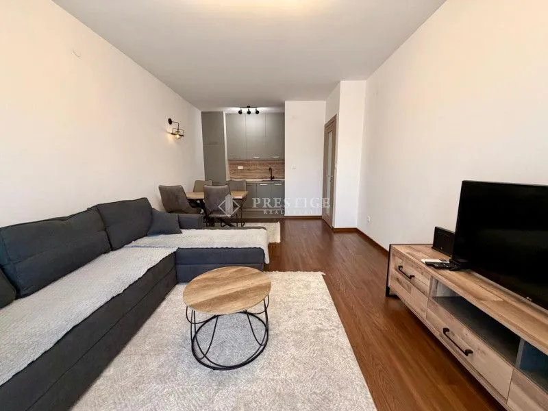 Living room with sofa and dining area in an open-plan layout.