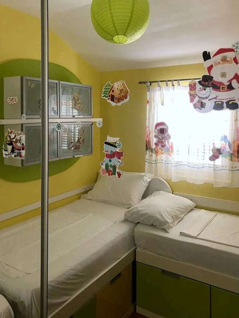 Children's bedroom with two single beds and holiday decorations.