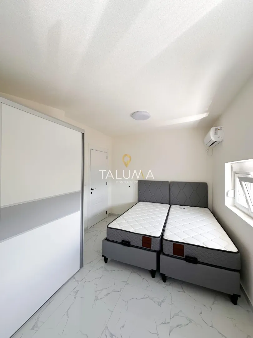 Bedroom with two beds and a white wardrobe.