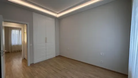 Empty bedroom with a built-in wardrobe and hardwood flooring. - image 6