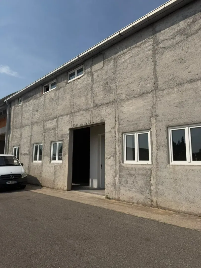 Exterior view of an industrial building with a grey facade and white windows.