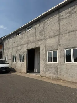 Exterior view of an industrial building with a grey facade and white windows. - image 8