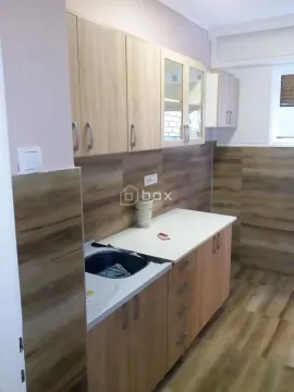 Smaller kitchen with wooden cabinetry and a sink. - image 9