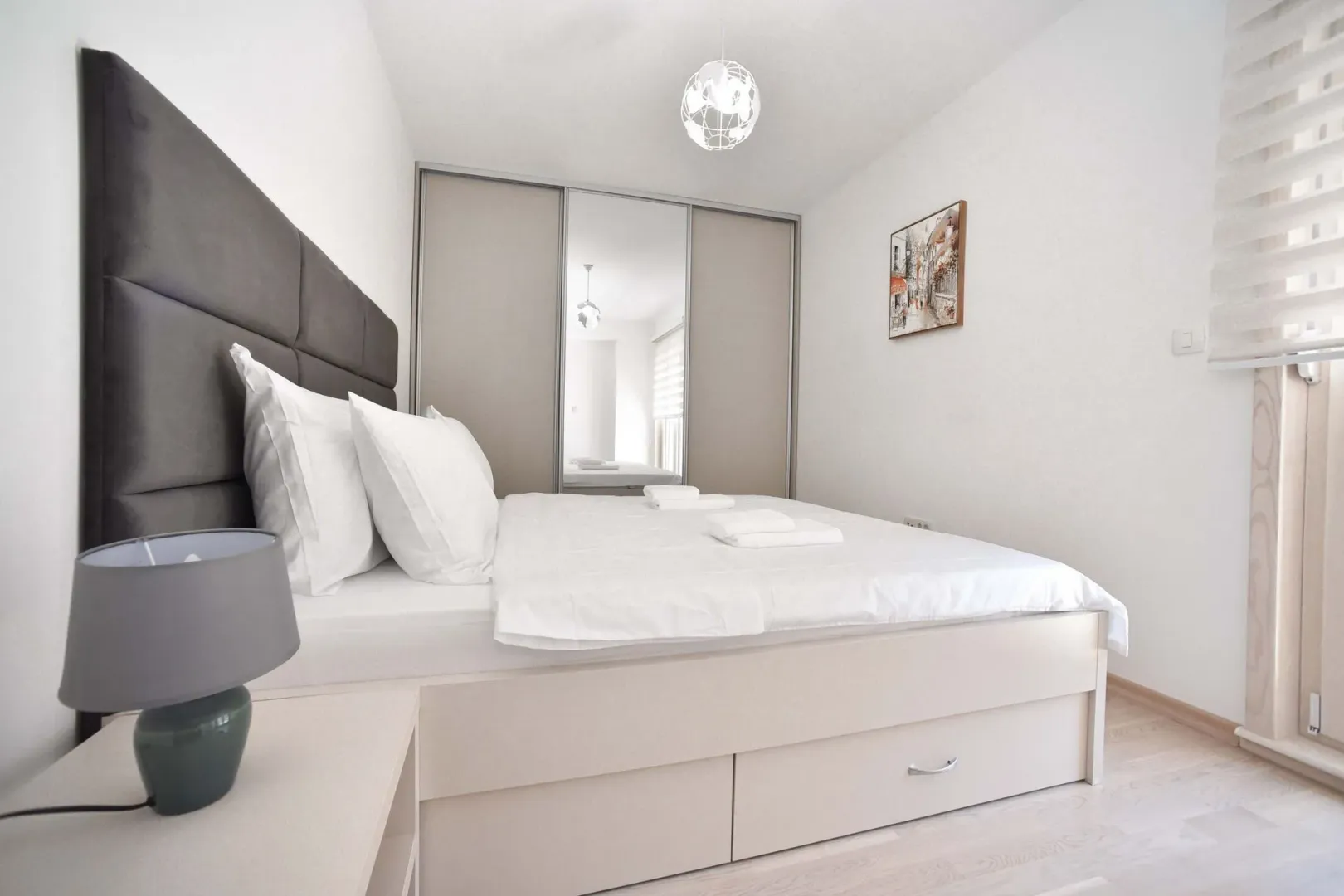 Modern bedroom with a double bed, built-in wardrobe, and nightstand.