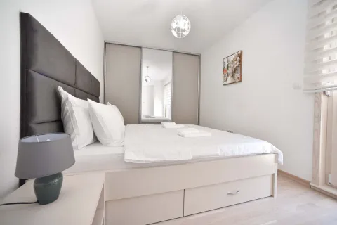 Modern bedroom with a double bed, built-in wardrobe, and nightstand. - image 11