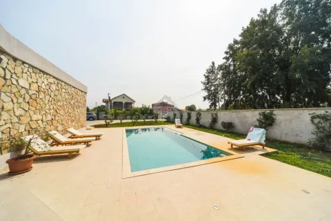 Swimming pool with sunbathing area and loungers in the yard. - image 13