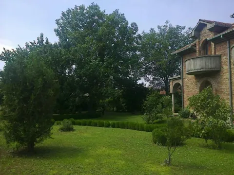 Zeleno dvorište sa travnjakom i drvećem pored kamene kuće. - image 9