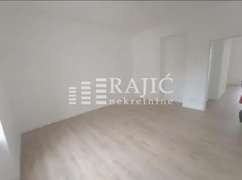 Empty room with light wooden flooring and white walls. - image 4