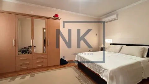 Furnished bedroom with a double bed, large wooden wardrobe, and air conditioning. - image 13