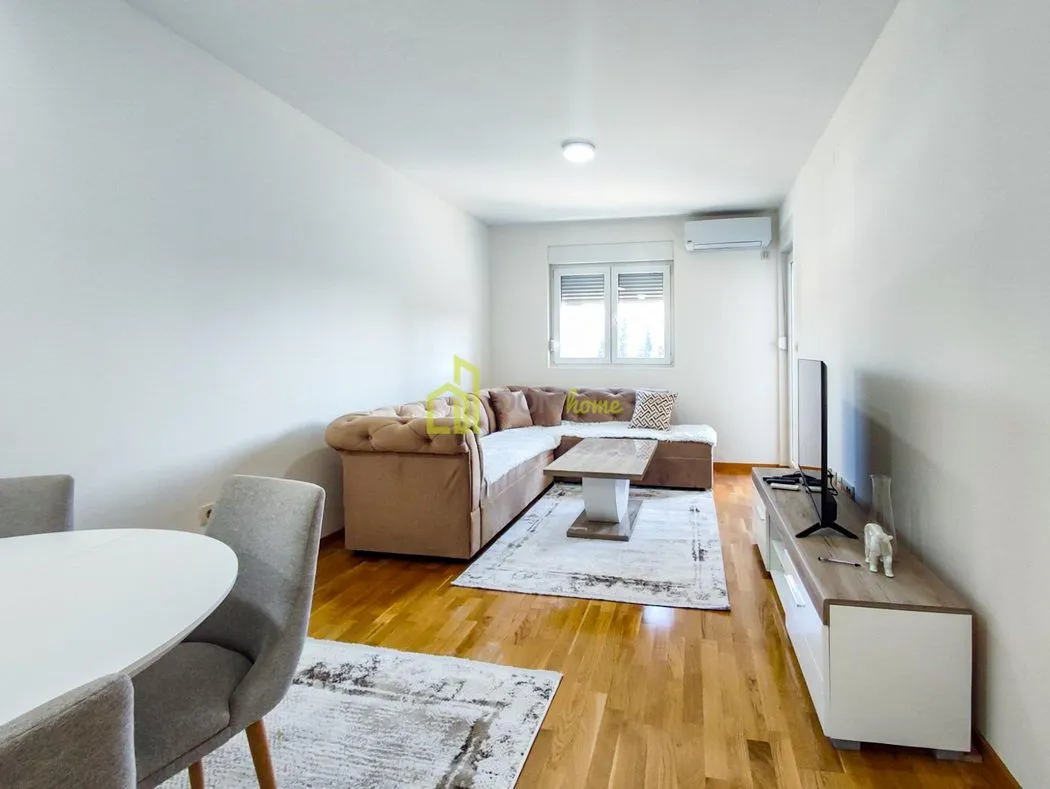 Living room with sofa, coffee table, and television.