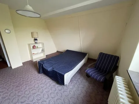 Nameštena spavaća soba sa krevetom, foteljom i policom. - image 27