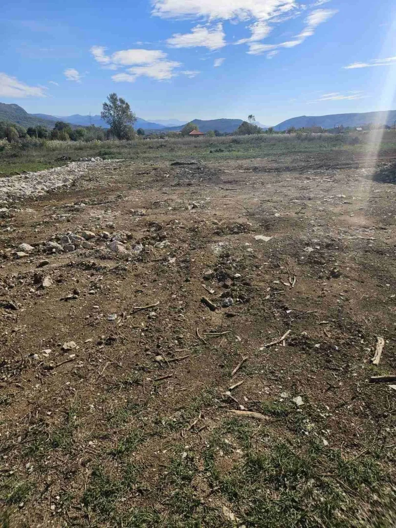 Prostrani ravan plac okružen prirodom i brdima.