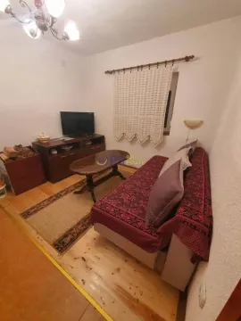 Manji dnevni boravak sa garniturom za sjedenje, televizorom i drvenim podom. - image 19