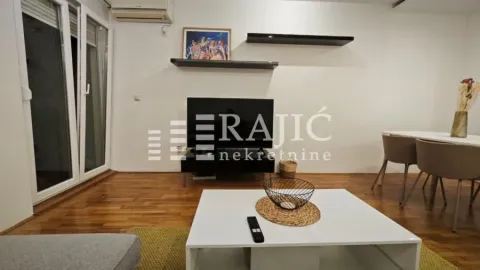 Living room with a sofa, coffee table, and dining table. - image 3