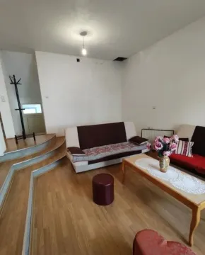 Dnevna soba sa garniturom za sedenje i drvenim podom. - image 7