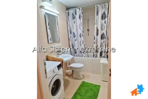 A compactly equipped bathroom with a bathtub, washbasin, and washing machine. - image 6