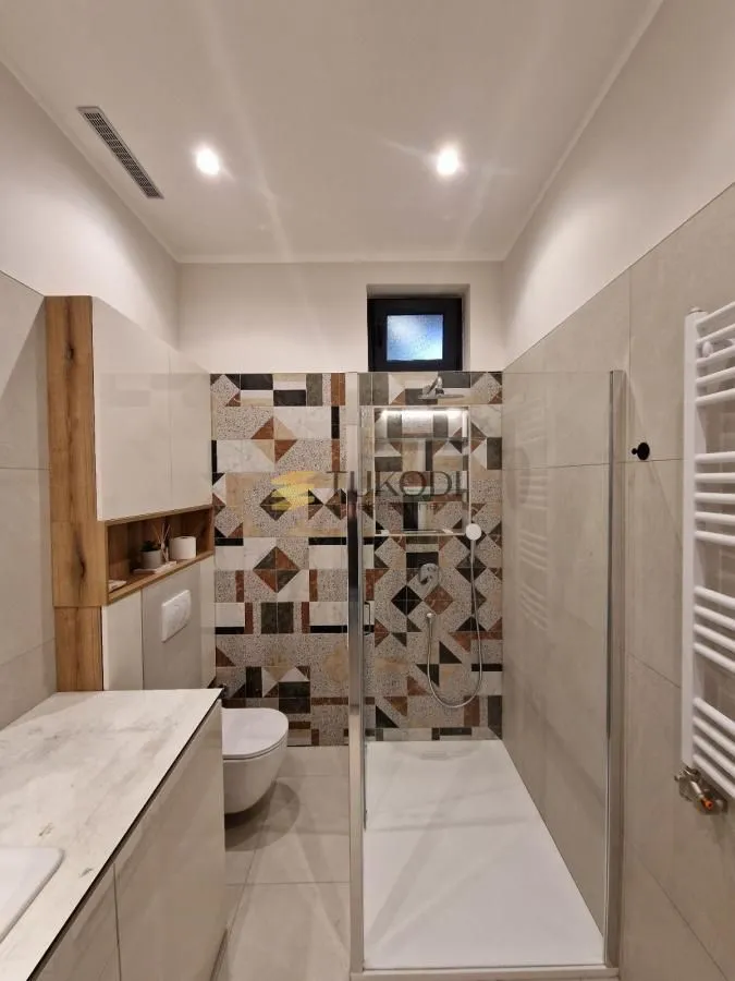 Modern bathroom with a shower cabin and built-in units.