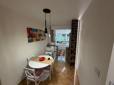 Trpezarija povezana sa kuhinjom sa drvenim podom i modernim osvjetljenjem. - image 2